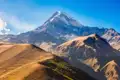 Die Swetizchoweli-Kathedrale in Mzcheta, Georgien. Die alten Steinmauern der Kathedrale erheben sich hinter einem Verkaufsstand mit bunten Tüchern.