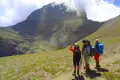 Wanderer mit Rucksäcken und Wanderstöcken betrachten und fotografieren einen Berg während ihrer Tour.