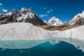 Ein Gletschersee reflektiert die umliegenden schneebedeckten Gipfel.
