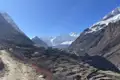 Bergdorf im Himalaya mit schneebedeckten Gipfeln im Hintergrund.