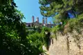 Die charakteristischen Türme von San Gimignano, gesehen von einem bewachsenen Weg aus.