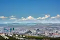 Stadtbild von Ulaanbaatar, Mongolei, mit Gebirge im Hintergrund und Jurtensiedlung im Vordergrund.