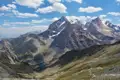 Schneebedeckte Berggipfel und ein Tal im Vordergrund.