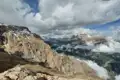 Panoramablick auf schneebedeckte Berggipfel und Wolkenformationen im Tal.