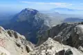 Aussicht von einem Berggipfel auf weitere Berge und ein Tal.