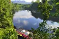 Entspannungsbereich am Fluss mit Liegestühlen und Sonnenschirmen.