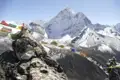 Gebetsfahnen und ein schneebedeckter Berggipfel im Himalaya.