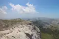 Wanderer auf einem Bergpfad mit Blick auf die umliegende Landschaft.