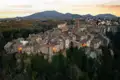 Luftbild einer historischen Stadt auf einem Hügel bei Sonnenuntergang.