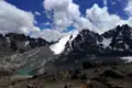 Spektakuläre Aussicht auf die schneebedeckten Gipfel und den Gletscher. Ein türkisfarbener See liegt eingebettet in der felsigen Landschaft.