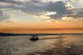 Boot mit Passagieren auf dem Fluss bei Sonnenuntergang.