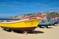 Fischerboote am Strand, möglicherweise Hinweis auf lokale Fischerei oder Bootstouren.