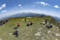 Wanderer ruhen sich auf einem Berggipfel aus und genießen den Panoramablick auf die Berglandschaft.