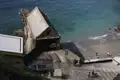 Historisches Bootshaus von 1914 an der Küste mit Besuchern am Strand.