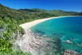 Abgeschiedener Strand mit türkisfarbenem Wasser und weißem Sand.