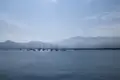 Ruhige Bucht mit Segelbooten und Bergen im Hintergrund.