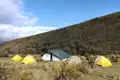 Campingplatz mit verschiedenen Zelten in den Bergen.