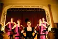 Tänzerinnen des Diamond Tooth Gerties in historischen Kostümen auf der Bühne.