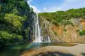 Spektakulärer Wasserfall mit Regenbogen im Sprühnebel.