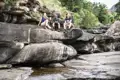 Wanderer ruhen sich während ihrer Wanderung auf Felsen an einem Fluss aus.