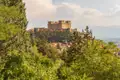Historisches Schloss auf einem Hügel mit Blick auf die umliegende Landschaft.