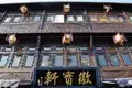 Fassade eines traditionellen chinesischen Gebäudes mit detaillierten Holzschnitzereien und hängenden Lampions.
