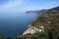 Panoramablick auf eine Küstenstadt an der italienischen Riviera, eingebettet zwischen bewaldeten Hügeln und dem Ligurischen Meer.