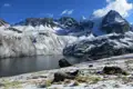 Bergsee mit schneebedeckten Bergen im Hintergrund.