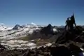 Wanderer auf einem Gipfel in den Anden mit Blick auf die umliegende Berglandschaft.