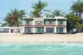 Hotelgebäude am Strand mit Palmen.