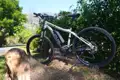 Silbernes E-Bike, Modell SX 5, abgestellt an einem Baumstamm.