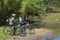 Zwei Radfahrerinnen pausieren während ihrer Radtour an einem See.