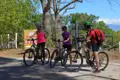 Drei Radfahrer machen eine Pause an einem Wegweiser während ihrer Radtour.