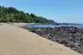 Küstenlandschaft mit Sandstrand und Felsen.
