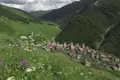 Traditionelles Bergdorf mit Wehrtürmen in einer idyllischen Berglandschaft.