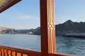 Aussicht von einem traditionellen Holzboot auf die bergige Küste.