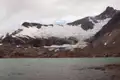 Blick auf einen Gletscher, der in einen Bergsee mündet.