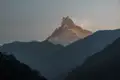 Schneebedeckter Berggipfel bei Sonnenaufgang.