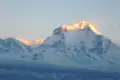 Schneebedeckter Berggipfel in der Morgensonne.