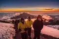 Wanderer besteigen einen verschneiten Bergpfad bei Sonnenaufgang.