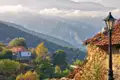 Traditionelles Haus und Laterne in einem Bergdorf mit Blick auf die umliegende Berglandschaft.