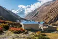 Traditionelles Bergdorf im Himalaya mit Blick auf die schneebedeckten Gipfel.