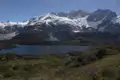Panorama eines Bergsees mit schneebedeckten Bergen im Hintergrund.