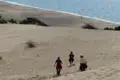 Wanderer auf einer Sanddüne mit Blick auf das Meer.
