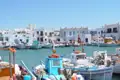 Fischerboote und weiße Häuser im Hafen einer griechischen Insel.