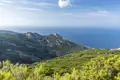 Bewaldete Berghänge und felsige Gipfel an der Küste mit Blick auf das Meer.