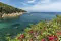 Schnorcheln im kristallklaren Wasser einer Bucht. Ein Segelboot im Hintergrund.
