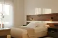 Doppelbett im Hotelzimmer mit Holz-Kopfteil und Nachttisch.