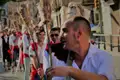 Männer tragen Holzstangen, Teil einer traditionellen Veranstaltung.
