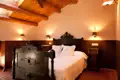 Antikes Bett im gemütlichen Schlafzimmer mit Holzbalkendecke.